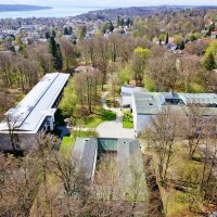 Luftbild auf den Campus, Häuser, Bäume, Starnberger See am Horizont sichtbar